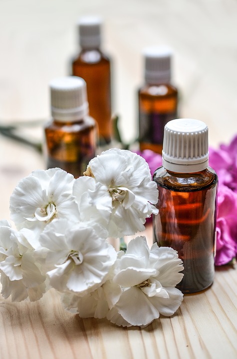 Image of bottles of massage oils with flowers laying next to them